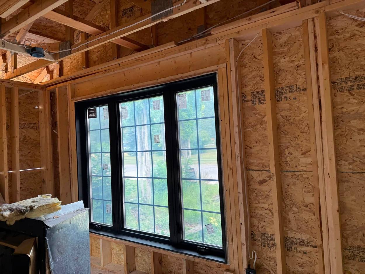 A new window set into fresh framing and sheathing during a Calgary renovation